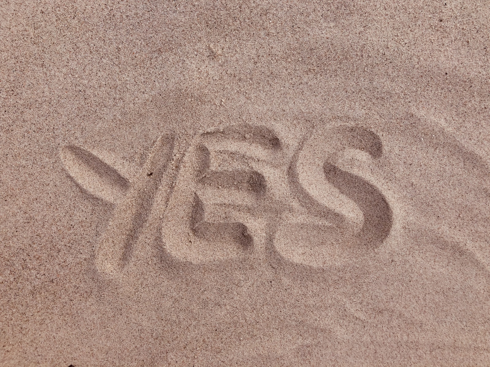 yes text on brown sand