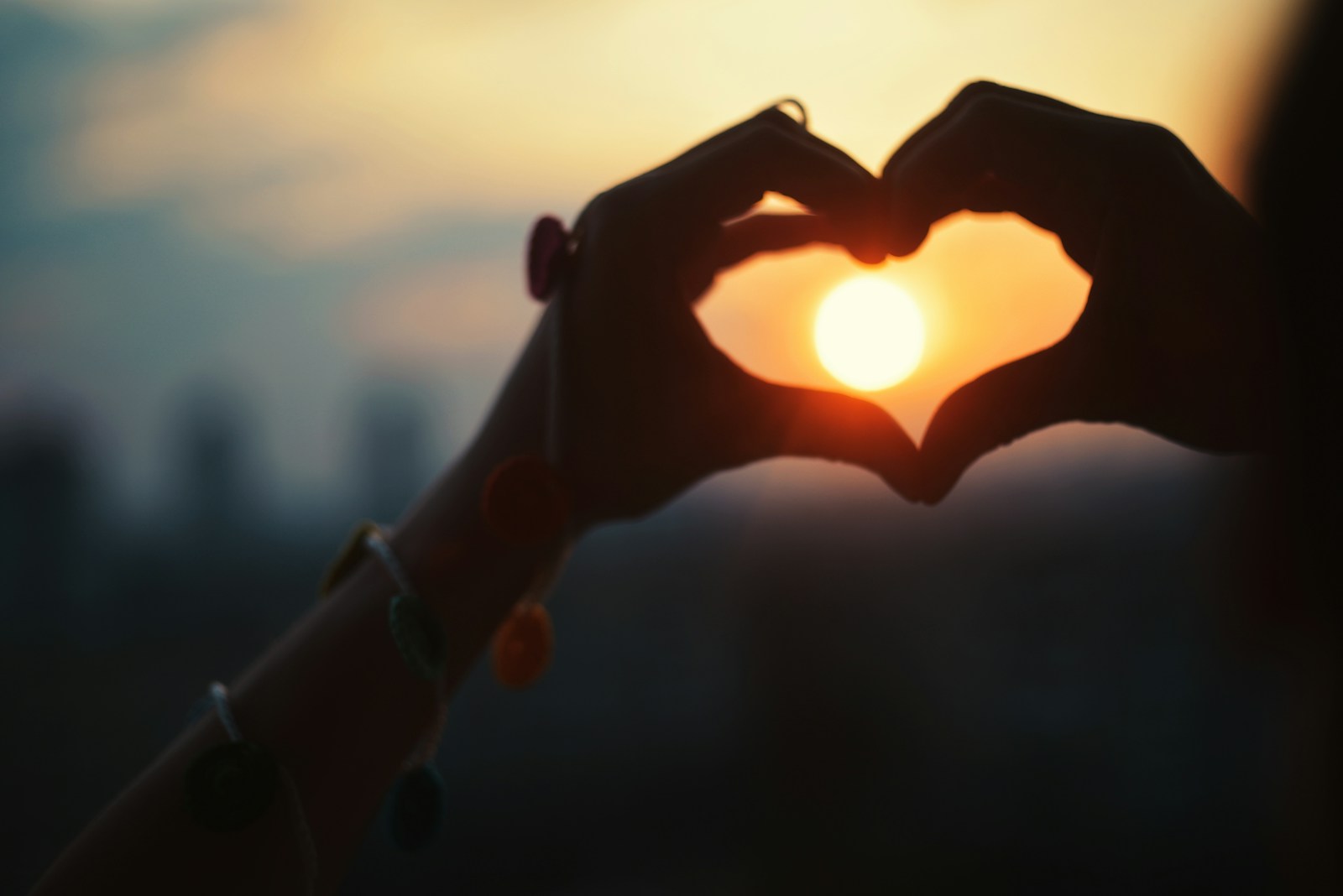 a person making a heart shape with their hands