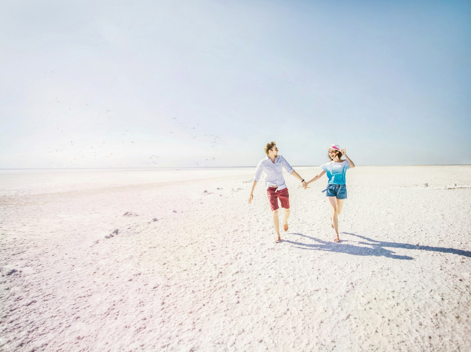 a couple of people that are walking in the sand