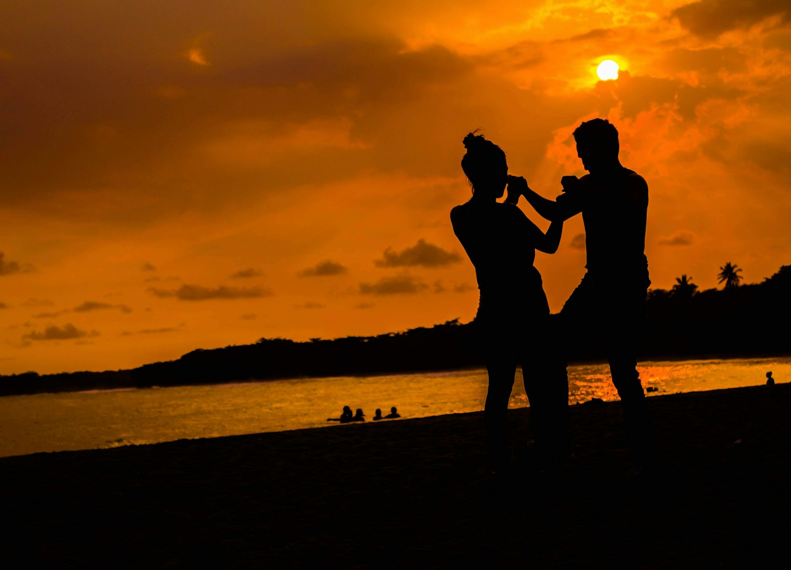 a couple of people standing on top of a beach
